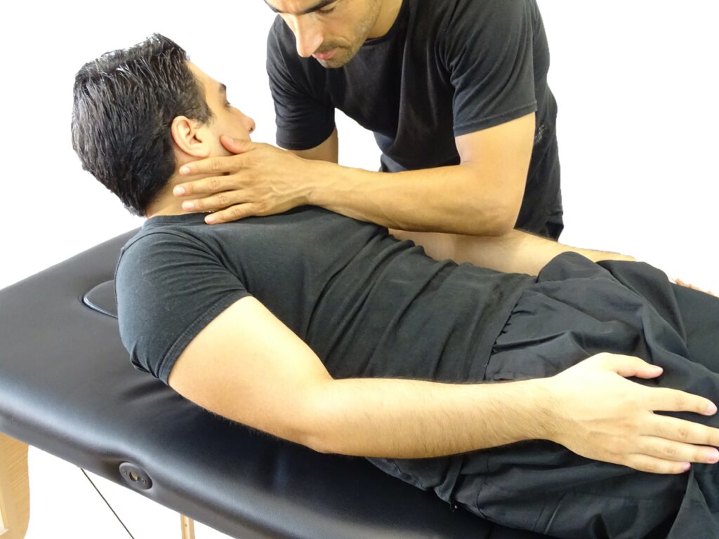 Readaptador postural evaluando la movilidad cervical y dorsal en camilla a un paciente con dolor de columna en Equilibrio Club Alicante